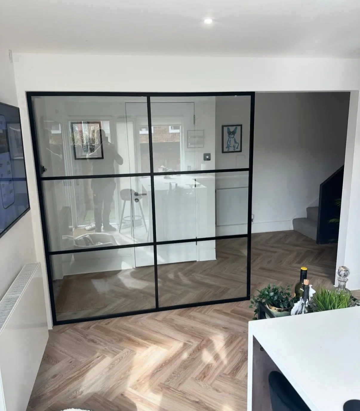 Black steel-framed glass partition and door fitted in a modern home interior