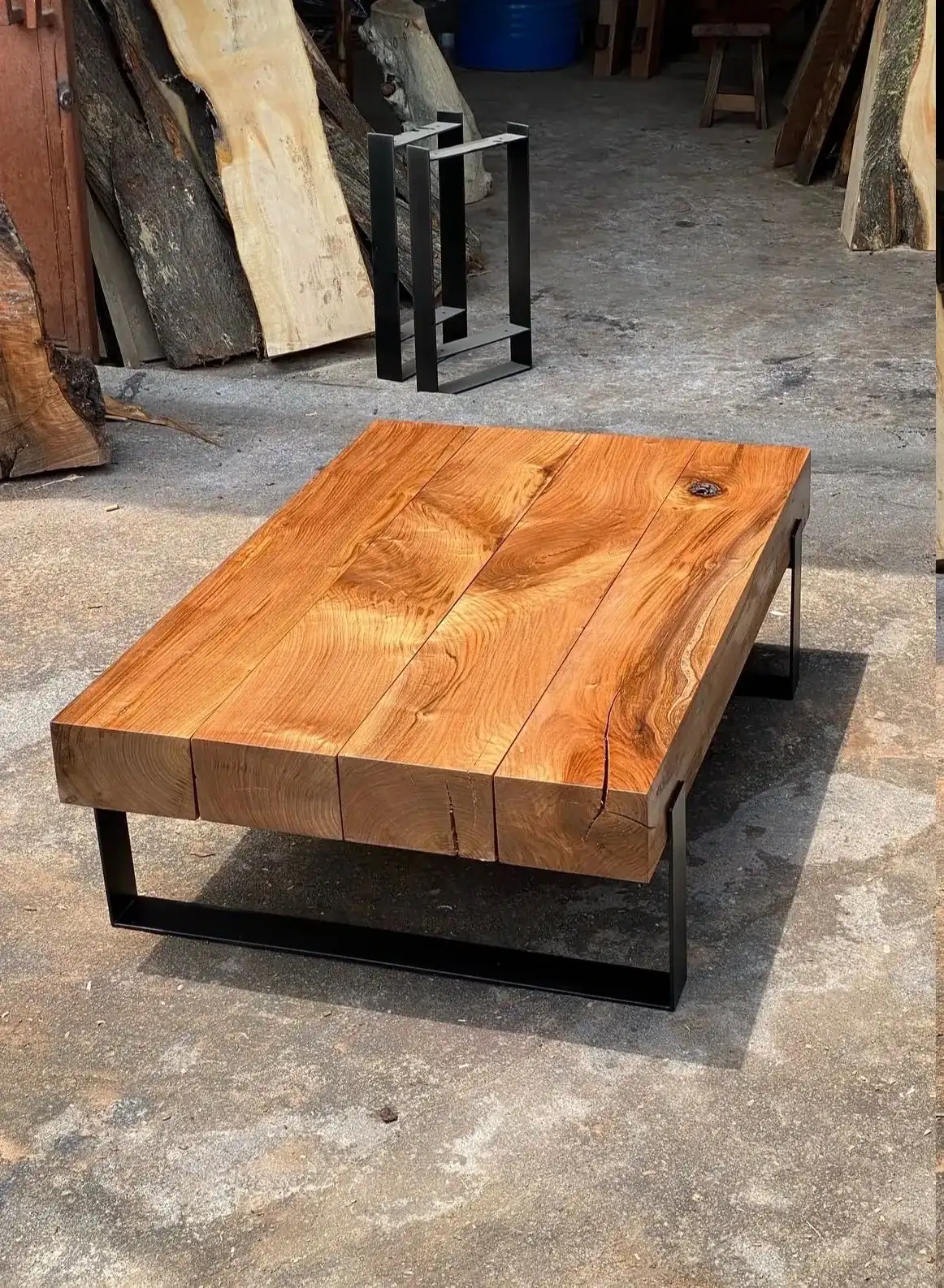 Solid timber coffee table top supported by a simple black steel frame